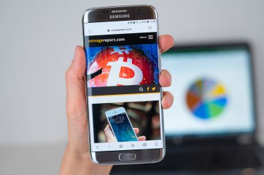 Telefon ekranında Coinagereport şirketin Web sitesi.