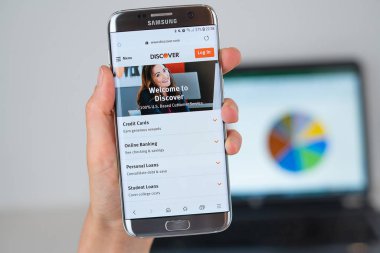 Telefon ekranında Discover şirketinin Web sitesi.