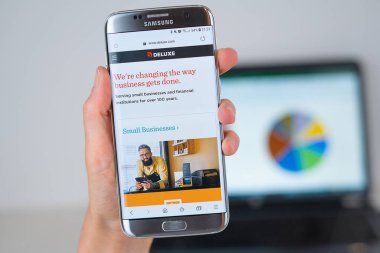 Telefon ekranında Deluxe şirketin Web sitesi.