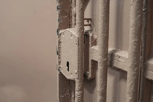 Metal door with bars in prison with lock — Stock Photo, Image