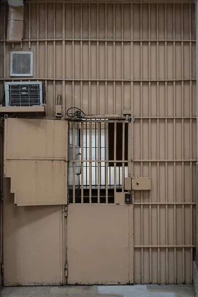 metal gates in prison with a large lock and thick bars