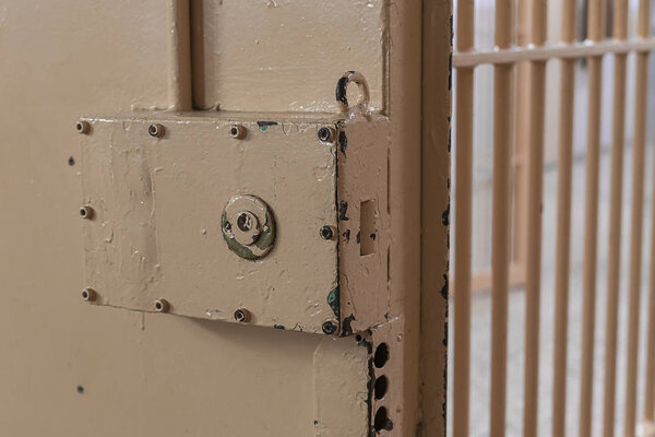 Big lock on prison door with bars.