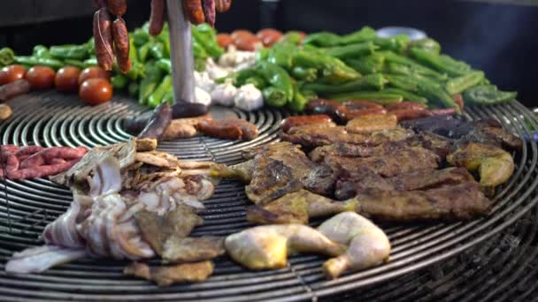 A szakács készít húst és zöldséget egy nagy grill a vásáron az esti órákban. — Stock videók