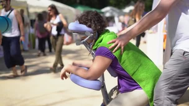 Mujer consiguiendo móvil silla masaje por hombre al aire libre — Vídeos de Stock