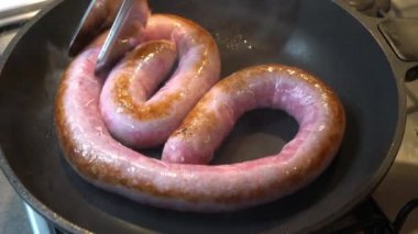 Cook bir tavada çok uzun bir sosis, La butifarra, pişirir.