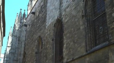 güneşli bir günde eski bir gotik katedralin pencereleri ile kule ve duvar