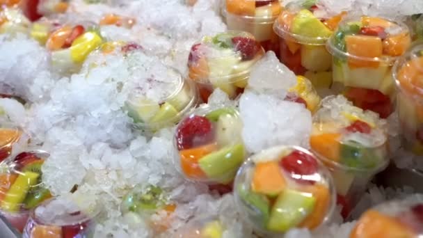 Шматочки фруктів у склянці льоду на ринку — стокове відео