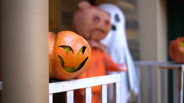 Kürbis und Gespenst auf der Veranda des Hauses während der Feier von Halloween. — Stockvideo