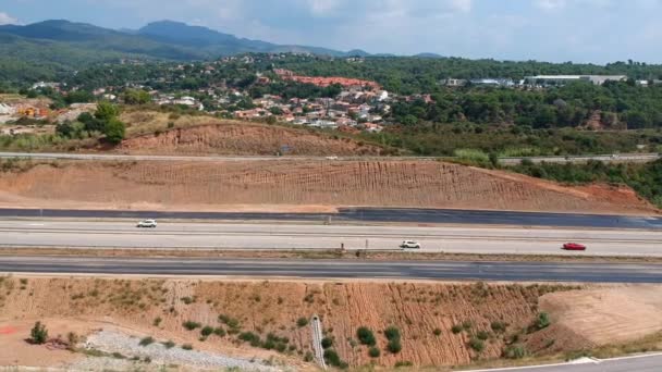 Vista aérea panorámica de una autopista suburbana. Drone vuela a lo largo del camino — Vídeo de stock