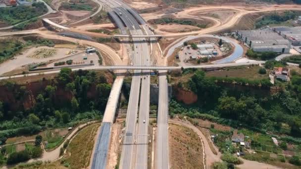 Vista aérea de amplia carretera con una gran rotonda y un puente — Vídeos de Stock