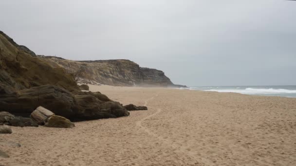 Plage océanique déserte près des rochers pendant une tempête — Video