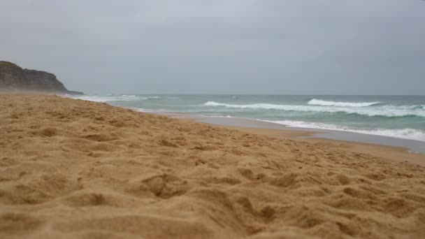 Sable propre au bord de l'océan. De fortes vagues océaniques sur fond de hautes falaises — Video