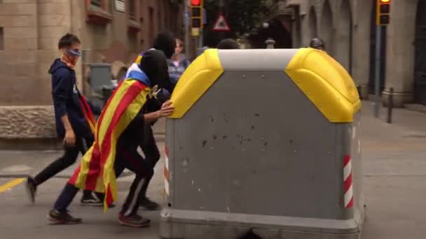 Młodzi ludzie ciągną kosz na śmieci wzdłuż drogi, aby zbudować barykady podczas zamieszek — Wideo stockowe