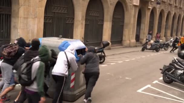 젊은이들은 거리를 따라 쓰레기통을 끌고 다니면서 폭동이 일어나는 동안 바리케이드를 설치 한다 — 비디오