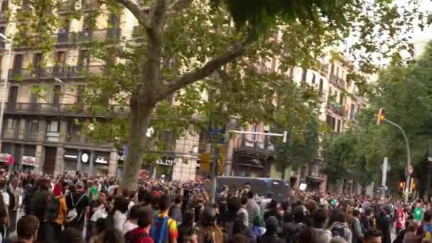 Des voitures de police blindées passent devant des manifestants lors d'émeutes à Barcelone . — Video