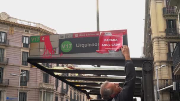 Uomo incolla un segnale di stop che dice "fuori servizio". alla fermata dell'autobus bruciata dai vandali — Video Stock