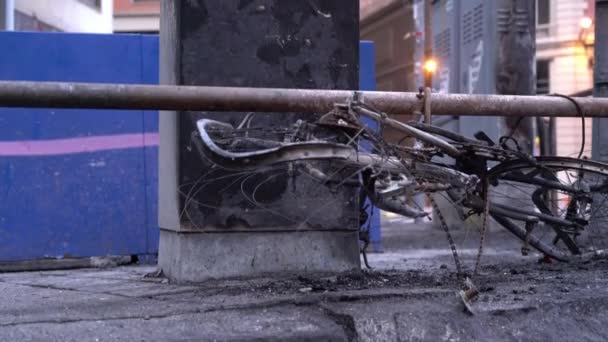 在街上发生骚乱后,一辆被烧毁的自行车停在一个被烧毁的电台亭旁边 — 图库视频影像
