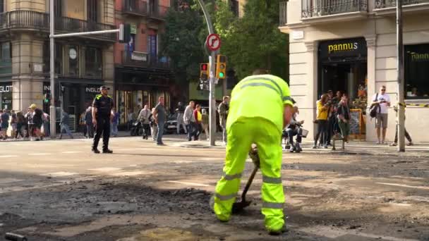 Road workers clean old asphalt with shovels from the road during road repair. — ストック動画