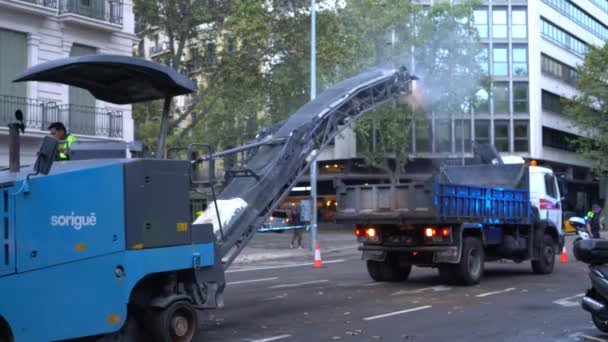 Équipement de construction enlève la couche d'asphalte de la route et les charges dans le camion — Video