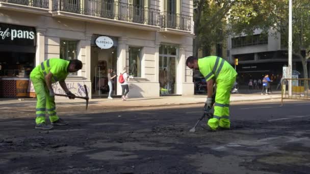 도로 인부들 이 착암기와 도끼를 가지고 도로에서 아스팔트를 제거하는 모습 — 비디오