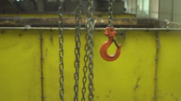Kovový hák na řetízku na pozadí obrovských kovových kontejnerů v továrně — Stock video