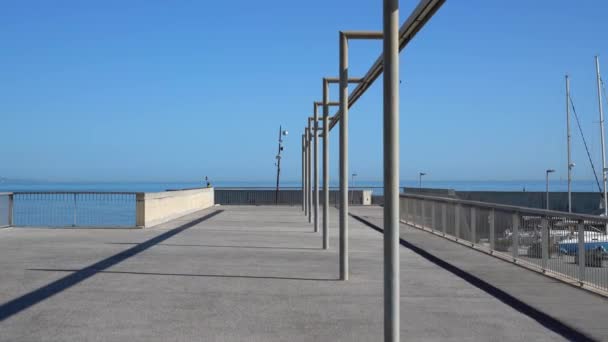 Movimiento a lo largo de los faroles en el muelle en la costa del mar — Vídeos de Stock