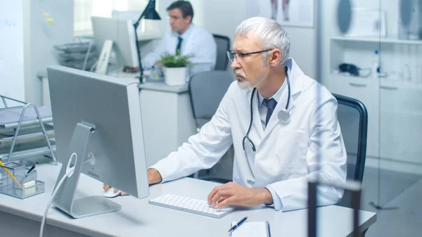 Senior Läkare Och Hans Assistent Arbetar Stationära Datorer Sitter Ljust — Stockfoto