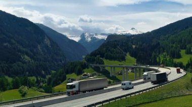 Ağır trafik Snowpeaks içinde belgili tanımlık geçmiş ile büyük dağlar vadi içine uzanan yolun hava atış.