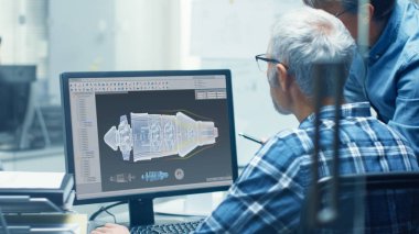 İki üst düzey uçak mühendis ile türbin çalışıyor bir kişisel bilgisayarda Blueprint. Onlar aktif olarak çeşitli planları ve düzenleri tartışmak.