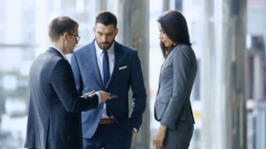Erkek ve kadın iş insanlar kullanma Tablet bilgisayar ve meşgul merkezi iş bölgesi sokakta duran süre yatırım fikirleri tartışmak.