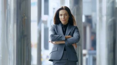 İş kadını Çapraz kollar ve gülümseme Central Business District sokağın ortasında duran.