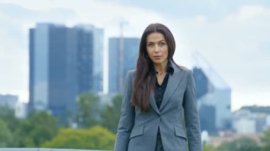 Başarılı iş kadını silah haçlar ve arka plan gökdelenler ve büyük kentin iş merkezine gülümsüyor olduğunu görünür.