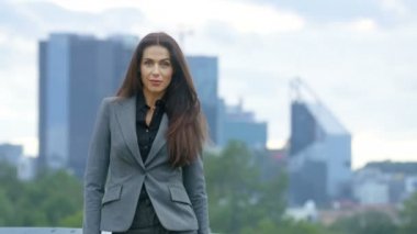 Başarılı iş kadını silah haçlar ve arka plan gökdelenler ve büyük kentin iş merkezine gülümsüyor olduğunu görünür.