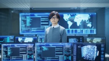 Sistem kontrol odasında akıllı mühendis gülümsüyor ve jest düşünüyorum yapar. Birden çok monitörü grafik ile yüksek teknoloji imkanı olup.