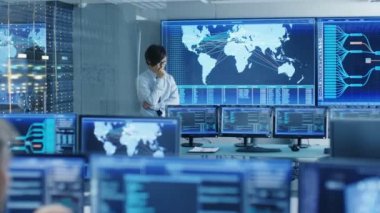 Sistem Denetim oda şef mühendis düşünüyor iken ayakta önce büyük ekran interaktif haritada ile. Veri merkezi tam, monitörler gösterilen grafik olduğunu.