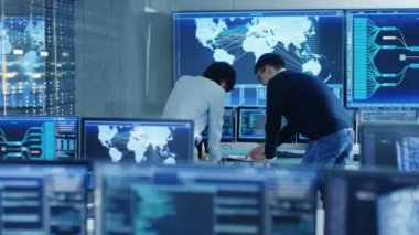 İçinde belgili tanımlık sistem denetim Oda projeyi yönetmek ve bu mühendis var tartışma, grafik ile birden çok monitör tarafından sarıldı. Büyük monitör etkileşimli lojistik harita gösterir.