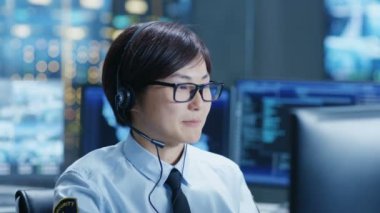 Network Operasyon Merkezi tüccar yapar kişisel istemci çağrısı ile bir kulaklık. Veri ve grafikler gösteren monitörler tarafından çevrilidir.