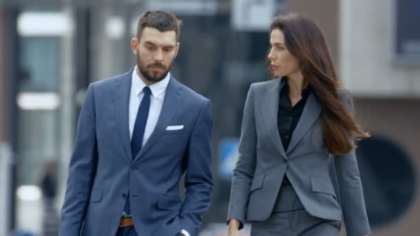 お互いビジネスを議論する大きな街を歩いて女性と男性のビジネス人々 の動きを遅きます スタイリッシュな古典的なテーラード スーツを着る — ストック動画