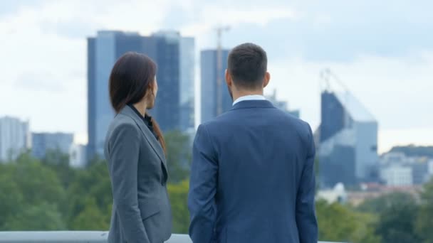 女性和男性商业人士在背景下与大城市摩天大楼讨论 — 图库视频影像