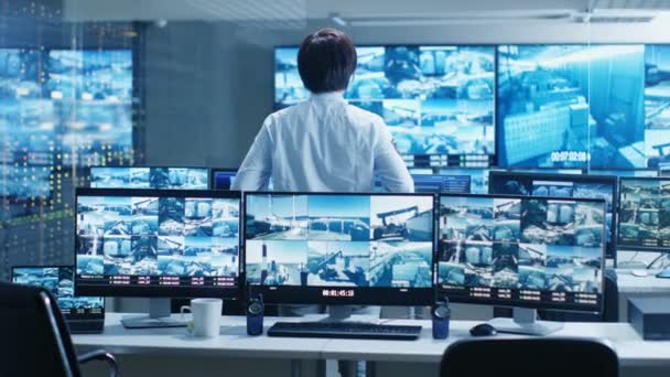 Güvenlik Kontrol Odasında Memur Birden Çok Ekran Şüpheli Hareketleri Izler — Stok video