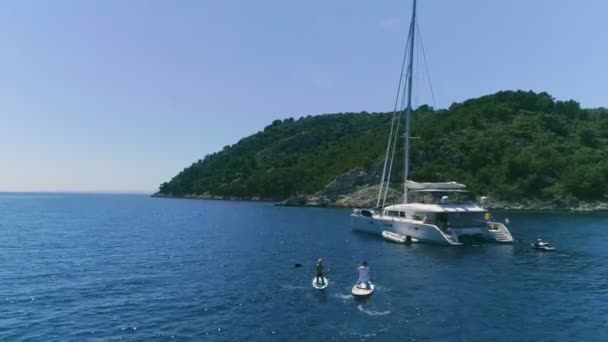 Aerial Shot Two Girls Standup Paddleboarding Sailing Yacht Luxury White — Stock Video