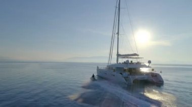 Beyaz yelkenli katamaran tekne ve Jet Ski tarafından sürüş hava görünümünü. Sakin ayna gibi deniz ve güzel bir gün güzel hava.