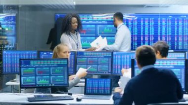 Tüccarlar çok etnik gruptan oluşan takım meşgul Menkul Kıymetler Borsası ofisinde çalışıyor. Bayi ve Broker satın almak ve satmak hisse senetleri piyasasında. Monitörler ilgili Infographics, veri ve sayıların görüntüsünü.