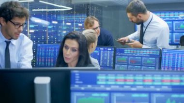 Çok etnik gruptan oluşan ekip, stok tüccarlar Menkul Kıymetler Borsası firma ofiste yoğun satış ve satın alma tahvil ve hisse var. Gösteri ilgili grafikler ve numaralarını görüntüler.