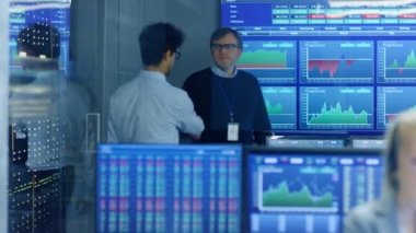 Stok tüccar Office ve sallar ellerin bir meslektaşı ile girer, diğer ilgili sohbet yapar çalışır. Office Broker, Bayi çok etnik gruptan oluşan ekibi ile meşgul. Gösteri numaraları ve Infographics görüntüler.