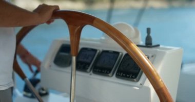 Yelkenli Yat tutan bir kaptan Close-up direksiyon. Pano deniz mili, derece ve rüzgar yönü gösterir. Sakin deniz içinde belgili tanımlık geçmiş.