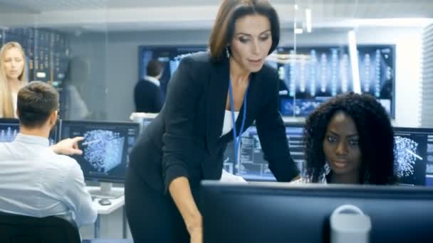 女性チーム リーダーは若いニューラル ネットワーク設計を調べます 彼らは 人工ニューラル ネットワーク上混雑しているオフィスで働く知能プロジェクト オフィス スペースはデータ サーバー — ストック動画