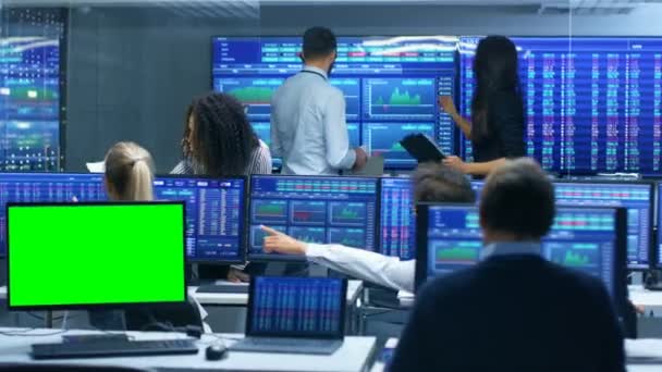 多民族的交易者团队正忙于在证券交易所办公室工作 一个显示器是绿色屏幕的模拟 经销商和经纪商在市场上买卖股票 显示器显示相关信息图表 数据和数字 — 图库视频影像