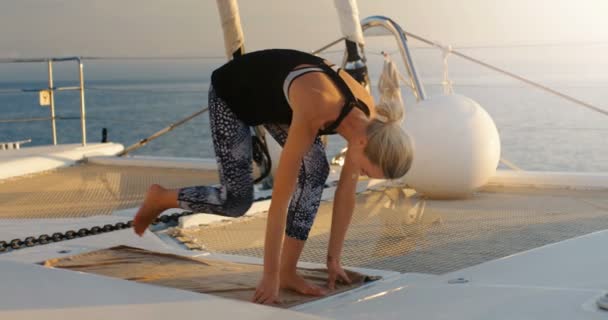 特写镜头的一个合适的年轻女子在帆船上做瑜伽 在背景美丽平静的海和晴朗的天空 — 图库视频影像