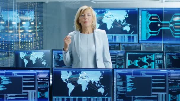 在系统控制室里 女总工程师描述了她的项目在镜头中交谈 在后台显示交互式数据的多个屏幕 — 图库视频影像
